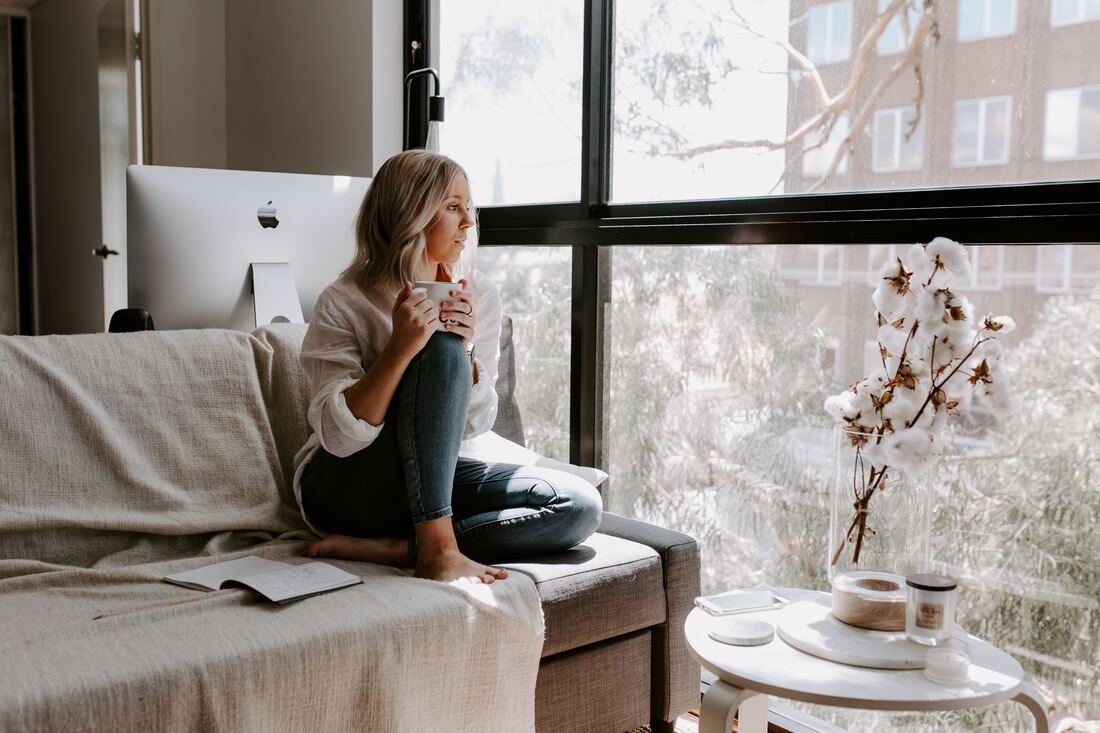 Female small business owner sitting on the couch with coffee