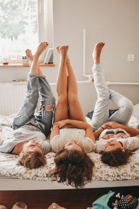 three women lying down with their feet in the air 